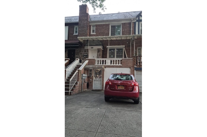 View of front of property with a high end roof, concrete driveway, brick siding, and an attached garage