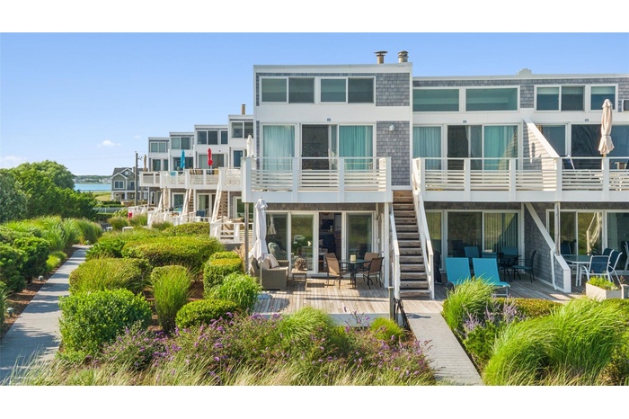 Rear view of property featuring stairs and a wooden deck