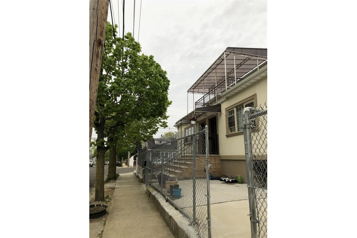 View of side of property with stucco siding and a balcony