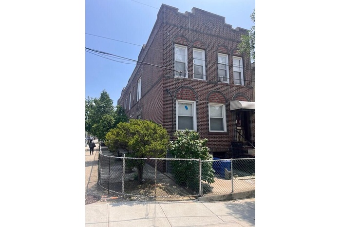 View of front of home with a fenced front yard and brick siding