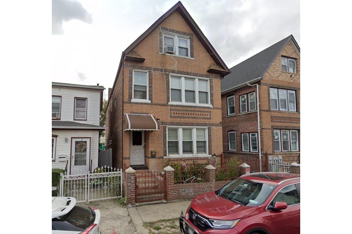 View of front facade featuring brick siding and a gate