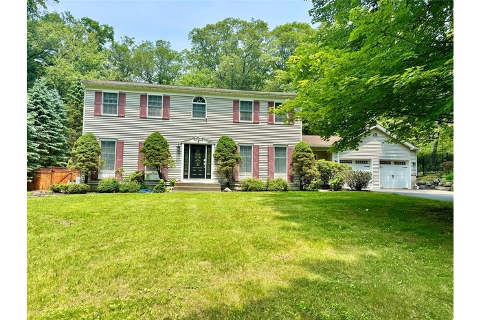 Colonial inspired home with driveway and an attached garage