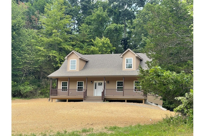 View of front of home featuring roof with shingles and covered porch