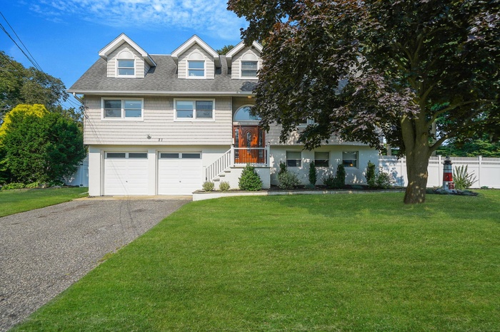 View of front facade with driveway, a shingled roof, and an attached garage