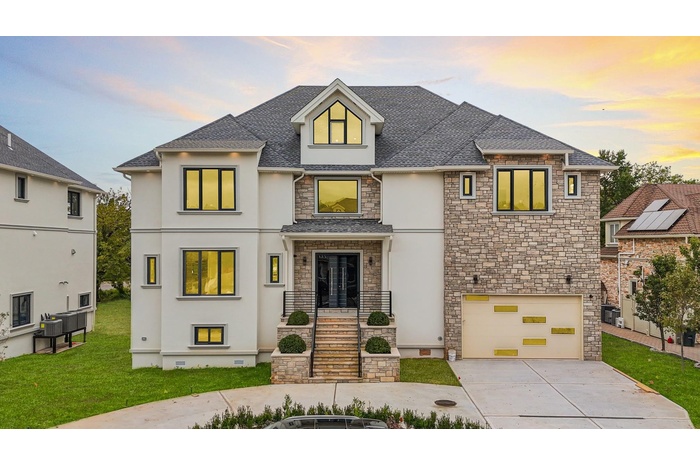 View of front of house featuring stone siding, stucco siding, concrete driveway, a yard, and a 2 car garage