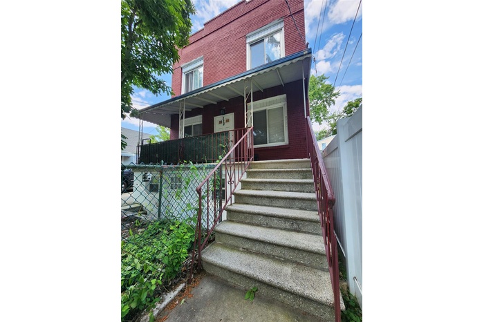 View of front of house with stairway, covered porch, and brick siding