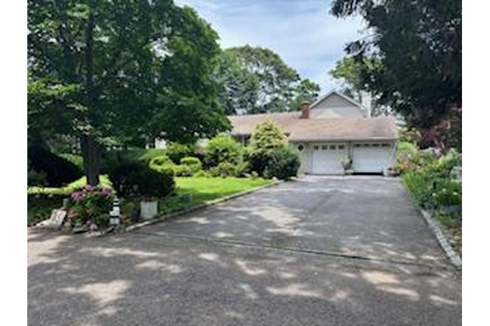 View of front of house featuring asphalt driveway and a garage
