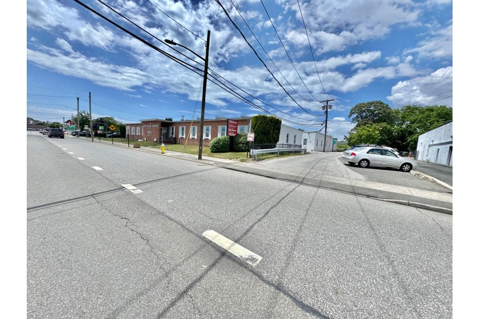 View of asphalt street with street lights, curbs, and sidewalks