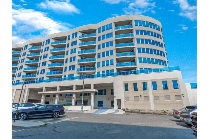 View of property featuring uncovered parking