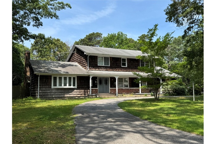 View of front of house with curved driveway.
