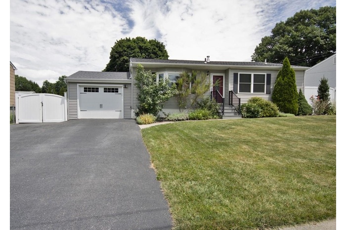 View of front of house with a gate, a garage, asphalt driveway, and a front lawn
