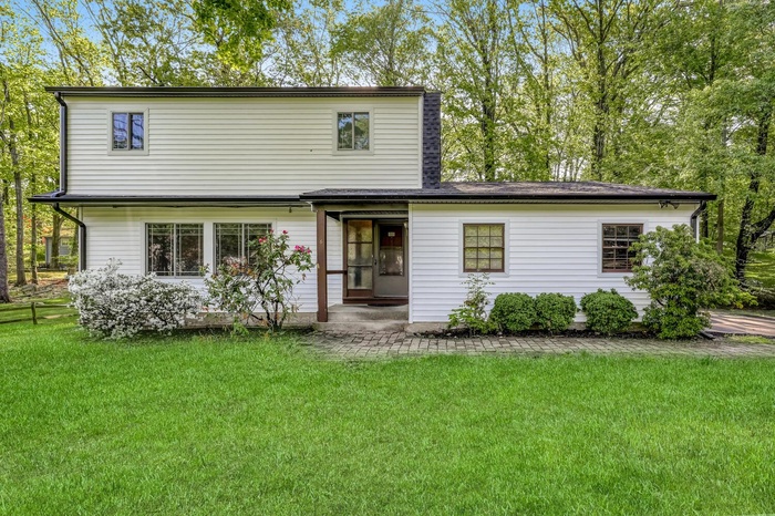 View of front of house featuring a front lawn and a chimney
