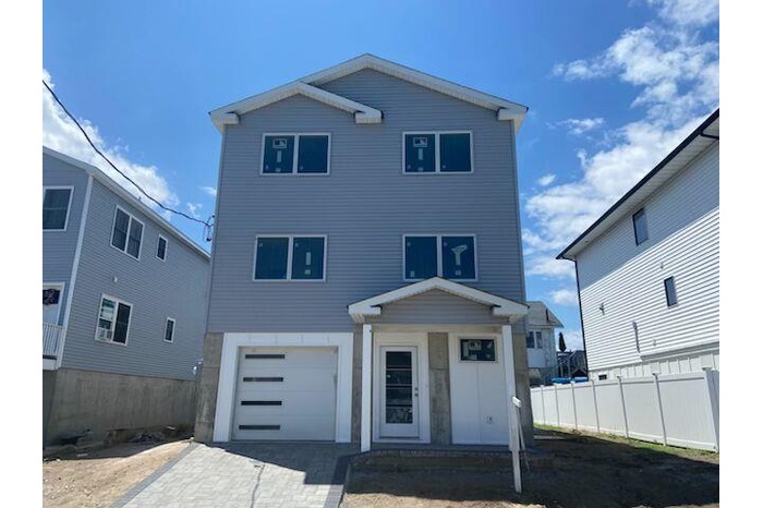 View of front of property with a garage and decorative driveway