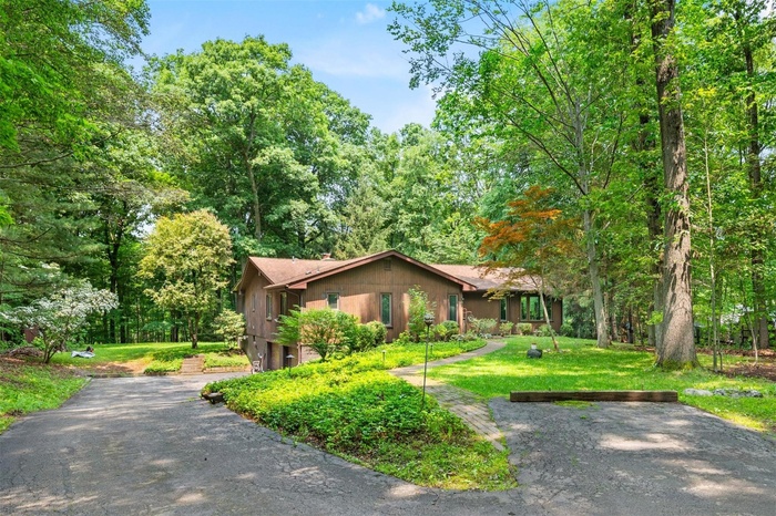 Single story home featuring a front lawn and asphalt driveway