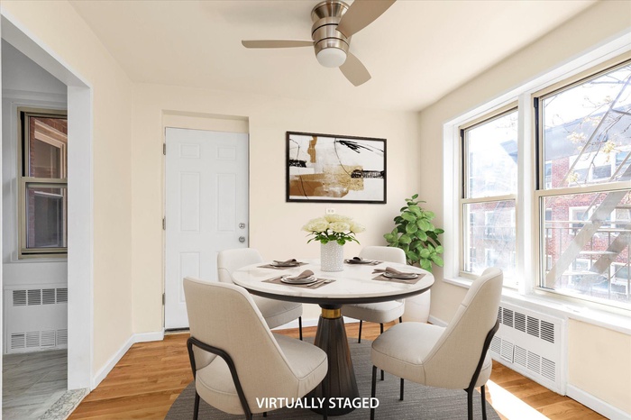 Dining area with radiator heating unit, baseboards, plenty of natural light, and light wood-style flooring