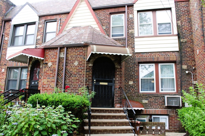 View of front facade featuring brick siding, a high end roof, and entry steps