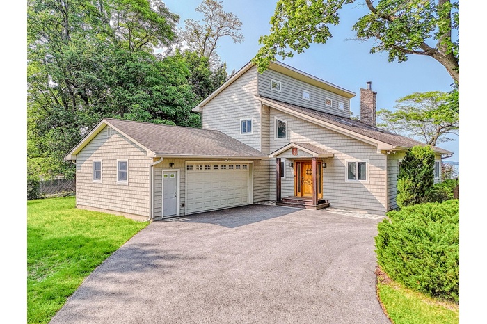 View of front of house featuring an attached garage and circular driveway