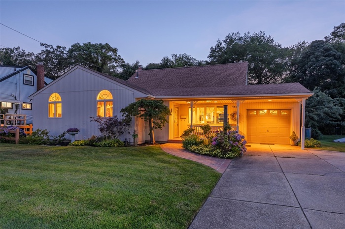 View of front of home featuring concrete driveway, an attached garage, a yard, and roof with shingles
