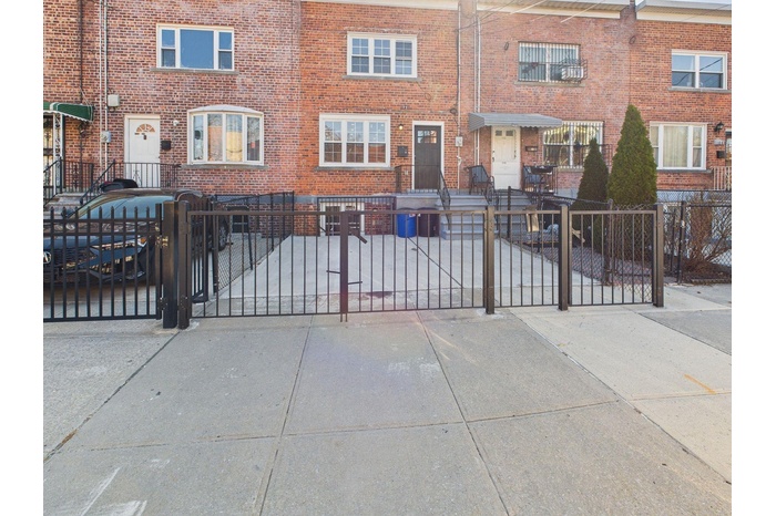 Townhome / multi-family property featuring a gate, brick siding, and a fenced front yard