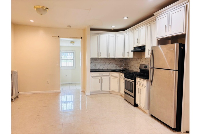 Kitchen with stainless steel appliances, backsplash, dark countertops, under cabinet range hood, and recessed lighting