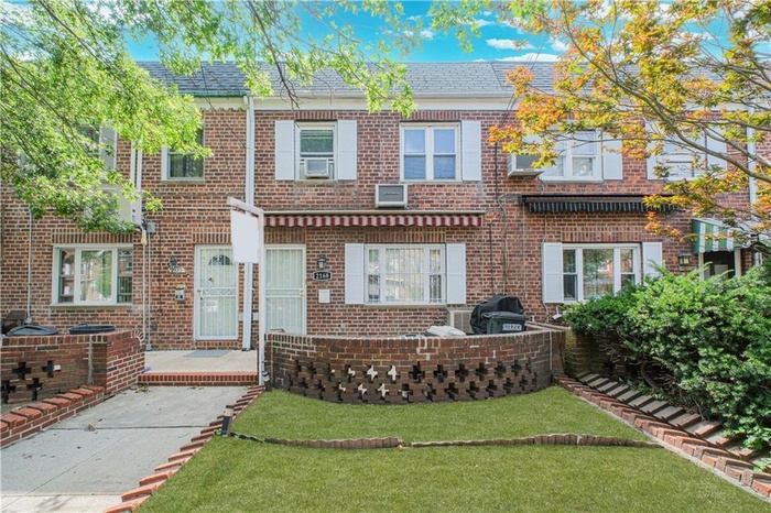 Traditional-style home with brick siding and a front yard
