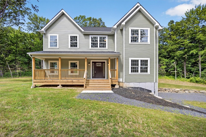 Traditional home with a porch and a front yard