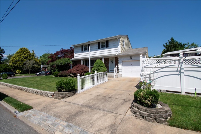 Traditional home featuring a garage, concrete driveway, and covered porch