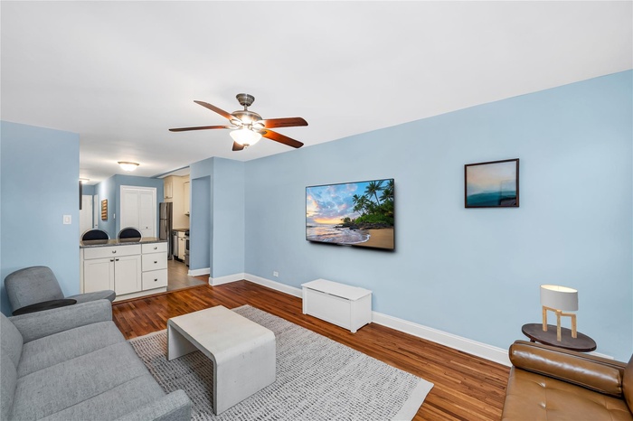 Living area with wood finished floors and ceiling fan