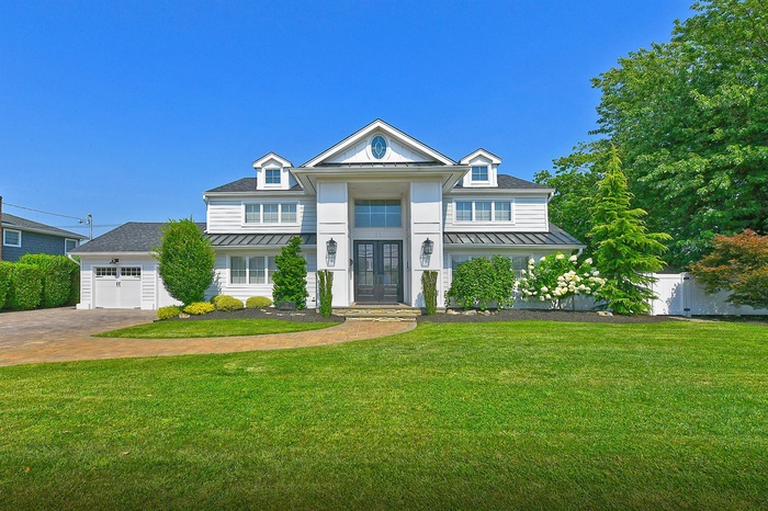 Neoclassical home featuring french doors, a standing seam roof, and a metal roof