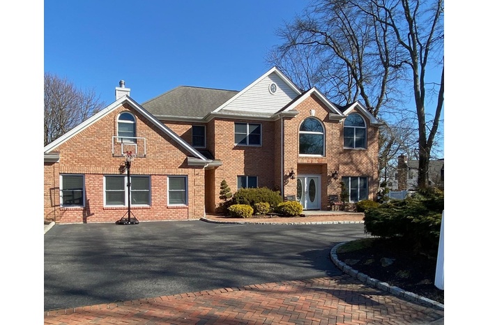 View of front of home featuring a chimney and brick siding
