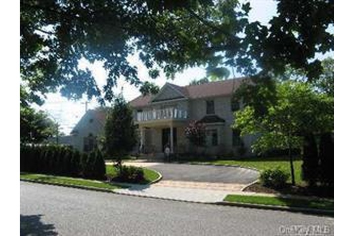 View of front of house with a balcony and driveway