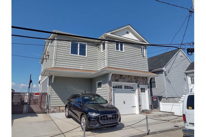 View of front of home featuring driveway, a garage, a gate, and a shingled roof