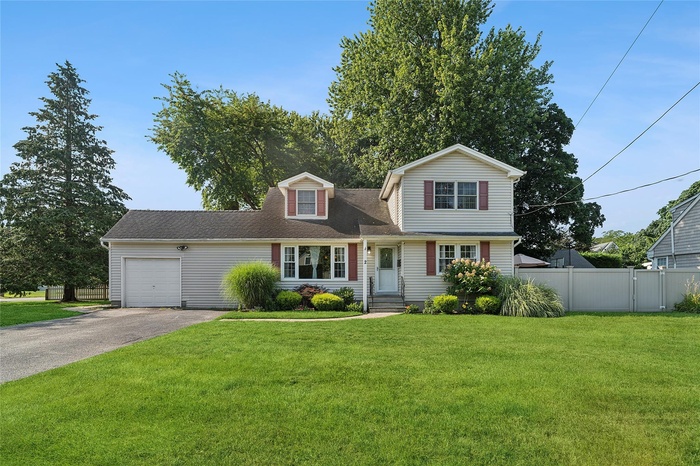 View of front of home featuring driveway, an attached garage, and roof with shingles