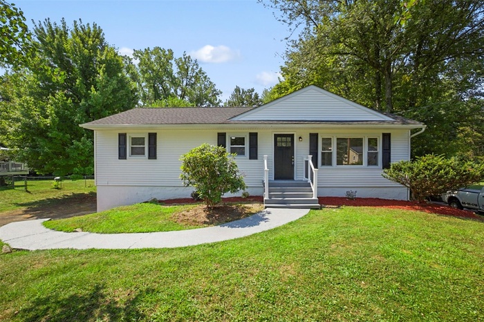 Single story home featuring a front lawn and covered porch