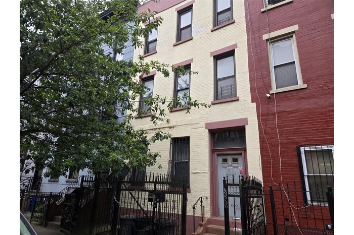 View of building exterior featuring a fenced front yard