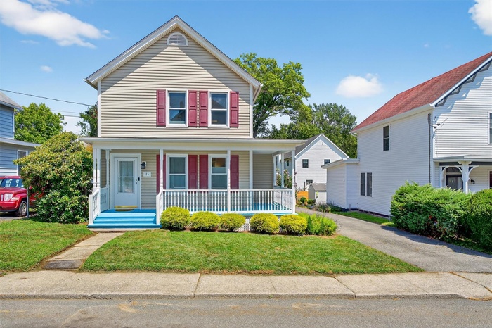 View of front facade with covered porch and a front yard
