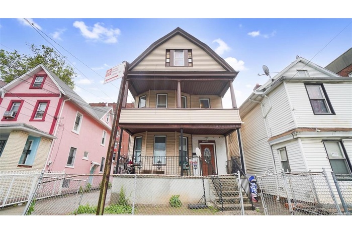 View of front of property with a porch, a gate, a fenced front yard, and a balcony