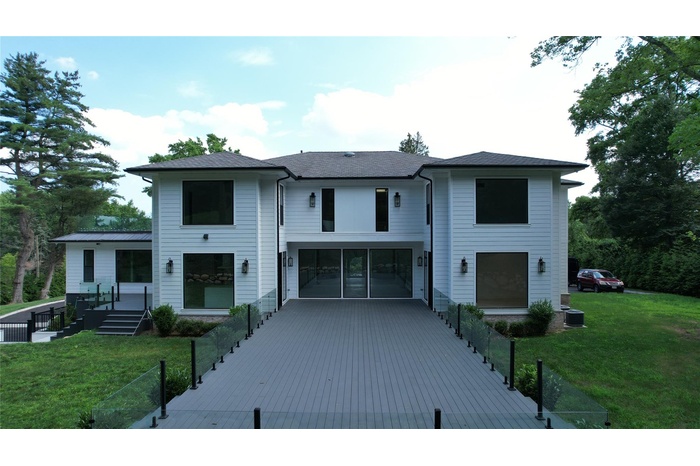 View of front of property with driveway, an attached garage, a front lawn, and roof with shingles