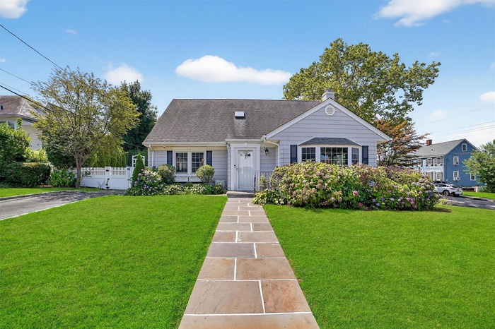 View of front of property with a chimney and roof with shingles