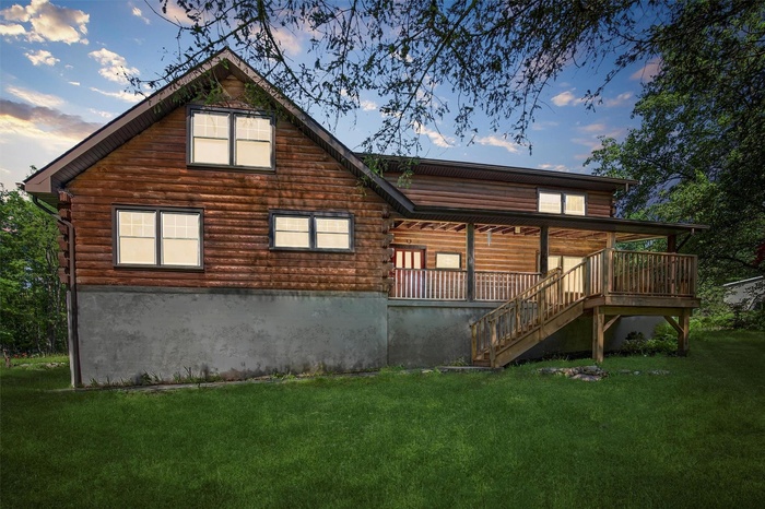 Front of property with a yard, stairway, and log exterior