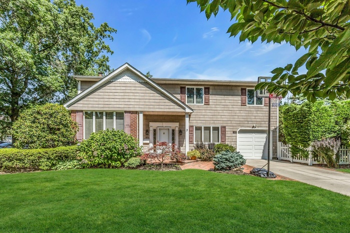 View of front of home with driveway and a garage
