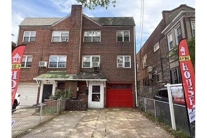 Townhome / multi-family property featuring an attached garage, driveway, a chimney, brick siding, and cooling unit