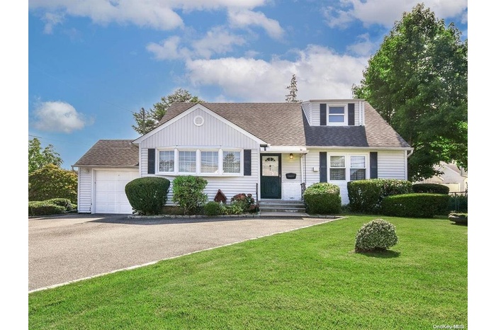 View of front of home featuring a garage and a front yard