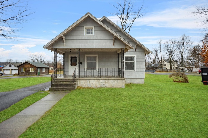 Bungalow-style home with covered porch and a front lawn