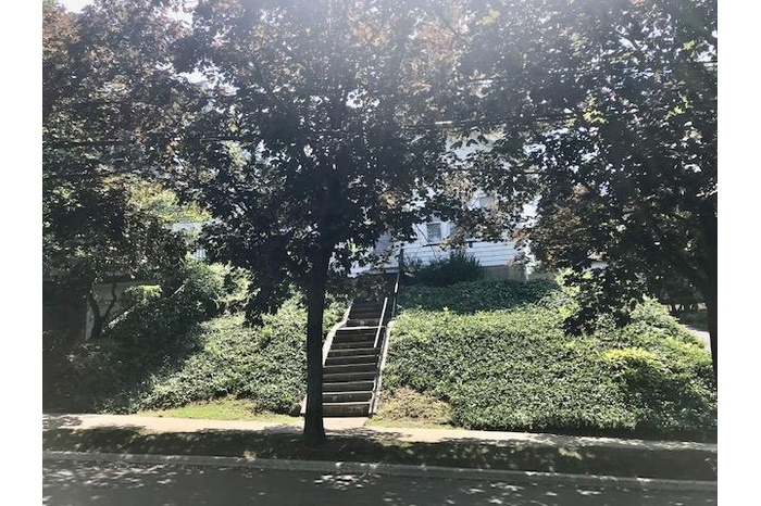 View of property hidden behind natural elements featuring stairs