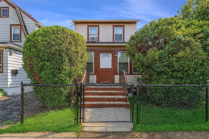 View of front facade featuring a gate and a fenced front yard