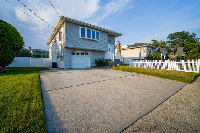View of front facade featuring a garage and concrete driveway