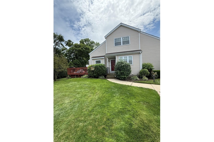 View of front of property featuring a front lawn and a deck