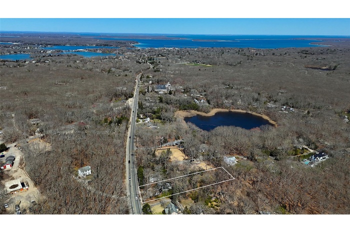 Aerial overview of property's location featuring a nearby body of water and property parcel outlined