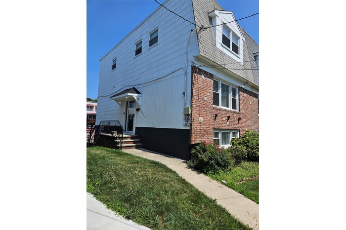 View of front of home featuring brick siding and a front yard